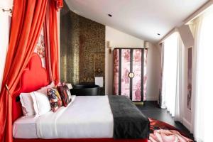a bedroom with a large bed with red curtains at Upon Angels - Adults Only in Lisbon