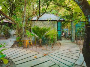 a walkway in front of a building with trees at Mi Lugar Maldives in Nolhivaranfaru