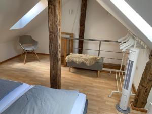 a attic room with a bed and a chair at Zentrale Altbauwohnung mit Flair in Schwäbisch Hall +5 photos
