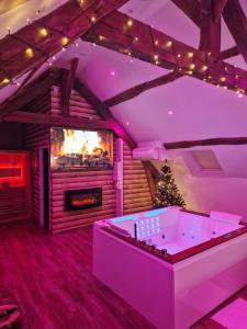 a living room with a tub and a fireplace at Suite Chalet avec jacuzzi YaoSpa60 in Laigneville