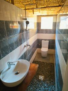 un baño con lavabo e inodoro en Bungalow Soa Majunga, en Mahajanga