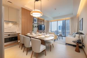 a kitchen and dining room with a table and chairs at Address Residences Dubai Opera - Burj Khalifa City Views 1, 2, & 3-Bedroom Apartment 1 minute walk to Burj Khalifa, Dubai Mall, Dubai Fountain by Heaven Crest in Dubai
