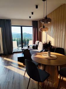 a living room with a table and a couch at Wśród Gór in Istebna
