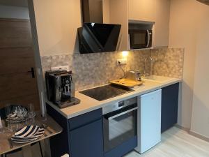 a kitchen with a sink and a microwave at L'Écrin d'Azurite in Saint-Clair-sur-les-Monts