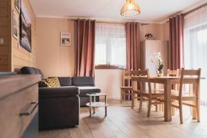 a living room with a couch and a table at Domki Pod Lasem Podhale in Zakopane
