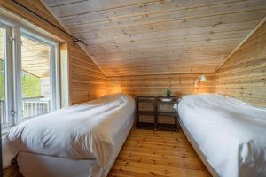 twee bedden in een kamer met houten wanden bij Lakehouse - 14p - With Sauna & By the Water in Vradal +28 foto's