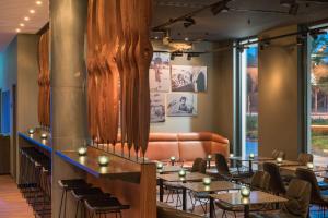 a restaurant with tables and chairs and a couch at Motel One Hamburg Airport in Hamburg