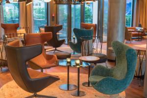 a row of chairs and tables in a room at Motel One Hamburg Airport in Hamburg