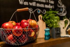 a basket of apples sitting on top of a table at Motel One Hamburg Airport in Hamburg