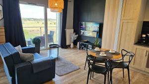 salon ze stołem, krzesłami i telewizorem w obiekcie Apartament Buk w mieście Buk
