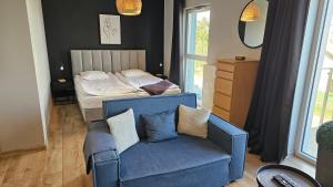 sypialnia z niebieską kanapą i łóżkiem w obiekcie Apartament Buk w mieście Buk +21 zdjęć