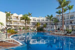 a swimming pool in front of a hotel at Apartamentos Parque del Sol in Adeje