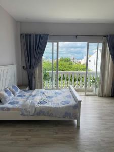 a bedroom with a bed and a large window at Homestay Ocean Real in Phan Thiet
