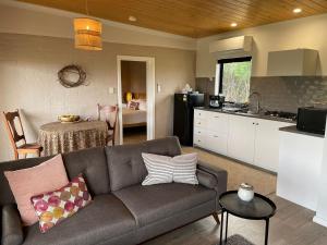a living room with a couch and a kitchen at Rosie's Cottage Bindoon in Mooliabeenee