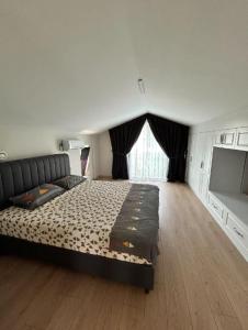 una camera da letto con un letto grande e una televisione di Villa Hisar a Seferihisar