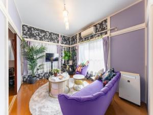 a living room with a purple couch and a table at Shinjuku, 3min walk from Nishi-Shinjuku 5-chome Sta, 3min Shinjuku Sta Switch, Wi-Fi ,Pocketwi-Fi in Tokyo