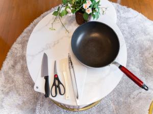 a pot on a white plate with scissors and a knife at Shinjuku, 3min walk from Nishi-Shinjuku 5-chome Sta, 3min Shinjuku Sta Switch, Wi-Fi ,Pocketwi-Fi in Tokyo