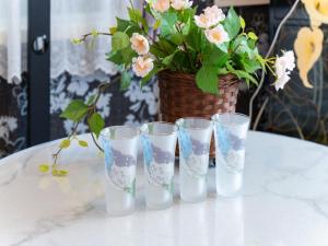 four glasses sitting on a table with a potted plant at Shinjuku, 3min walk from Nishi-Shinjuku 5-chome Sta, 3min Shinjuku Sta Switch, Wi-Fi ,Pocketwi-Fi in Tokyo