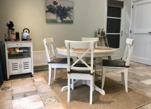a dining room with a white table and chairs at Stalhuis, overnachten in een tinyhuis bij de paarden in Nieuwleusen