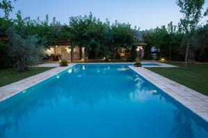a large blue swimming pool in front of a house at Casa Valley Boutique in Melegis