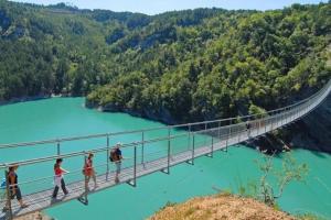 people walking across a suspension bridge over a river at -Retour vers le futur- EVG,EVJF,fêtes bienvenues! in La Mure