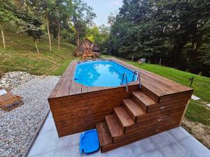 a swimming pool with a wooden deck around it at FRAMI Holiday Home in Klanjec