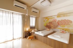 大阪市にあるV の Boutique Houseの壁に絵が飾られた部屋にベッドが2つある