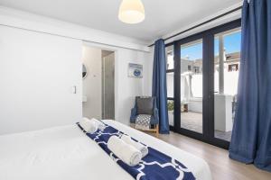 1 dormitorio con 1 cama con cortinas azules y ventana en Uptown Retreat by Host Agents, en Ciudad del Cabo 39 fotos más