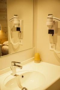 a bathroom with a sink and a mirror at Hotel Le Faranchin in Villar-dʼArène