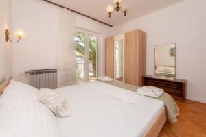a bedroom with two white beds and a mirror at Apartments Ivan in Novalja
