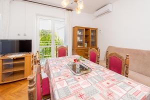 a dining room with a table and a television at Apartments Ivan in Novalja