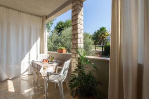 balkon ze stołem i krzesłami oraz oknem w obiekcie Apartment in Porec/Istrien 10034 w Poreču