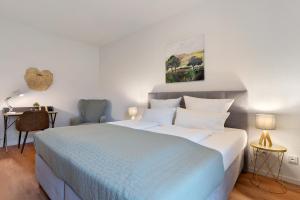 Un dormitorio con una cama azul y blanca y un escritorio. en Km Style Apartment Nr 2, en Freiburg im Breisgau