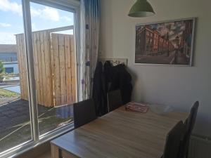 a dining room with a table and a large window at Dorpszicht krabbendijke centrum in Krabbendijke