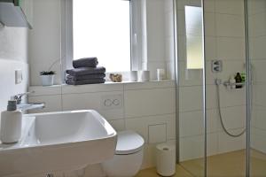 Un baño con lavabo, inodoro y ducha. en Quartier Wellant, en Weißensberg 12 fotos más