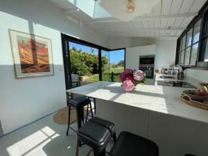 a kitchen with a counter with chairs and flowers on it at Les coquilles la Torche in Penmarcʼh