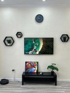 een woonkamer met een klok aan de muur bij Уютная однушка в центре города in Atıraw +2 foto's