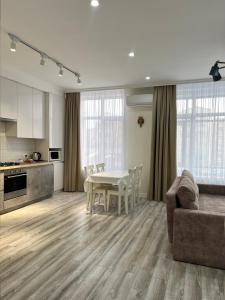 een keuken en woonkamer met een tafel en een bank bij Уютная однушка в центре города in Atıraw