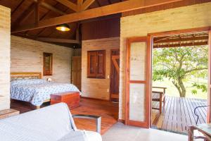 a bedroom with a bed and a sliding glass door at Magnificat Cottage in Cunha