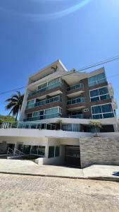 a large building with palm trees in front of it at Flats no Nixxus Residence (Flats da Elena) in Porto De Galinhas