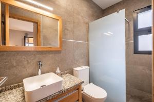 een badkamer met een wastafel, een toilet en een spiegel bij Salsa Country House II in Lanceiros +28 foto's