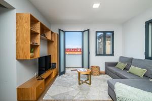 een woonkamer met een bank en een tv bij Salsa Country House II in Lanceiros