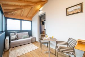 een woonkamer met een bank, een tafel en stoelen bij Salsa Country House II in Lanceiros