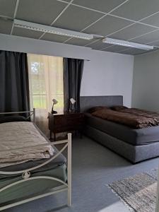 een slaapkamer met 2 bedden en een raam bij Ainola in Hämeenlinna