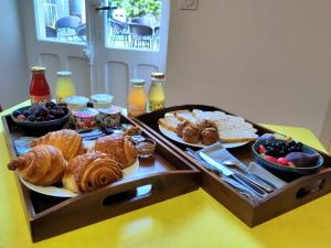 a table with a tray of pastries and other breakfast foods at Le25 Parahotellerie in Montbron +25 photos