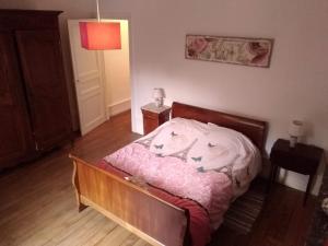 a bedroom with a bed with a pink comforter at l'èrmitage in Floing