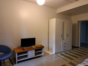 a room with a desk with a television and a cabinet at Ainola in Hämeenlinna