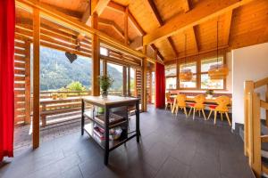une salle à manger avec une table, des chaises et des fenêtres dans l'établissement Schöneben Chalet Scorleduyn, à Wald im Pinzgau