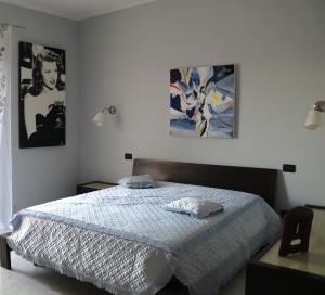 una camera da letto con un letto e due quadri sul muro di Albachiara B&B a Lucera