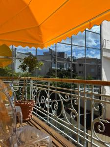 an orange umbrella on a balcony with a view of a city at Medουσία Wellness Spa Heritage Suites in Chalkida